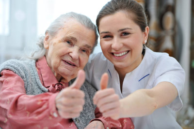 elderly and caregiver doing thumbs up