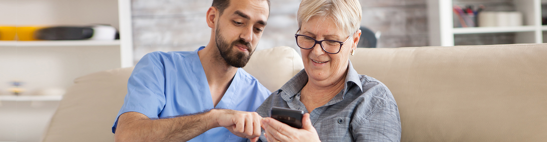 caregiver assisting the elderly using smartphone